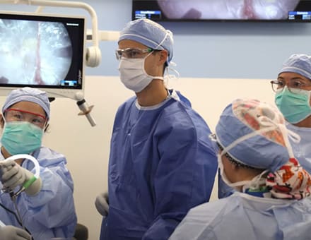 surgeons and residents in operating room.